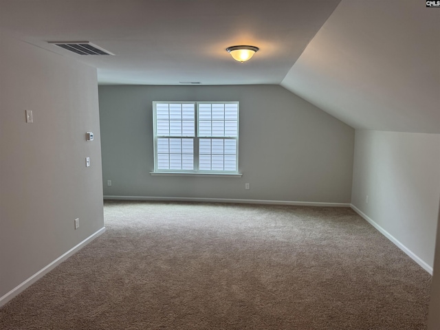 bonus room featuring carpet flooring, visible vents, vaulted ceiling, and baseboards