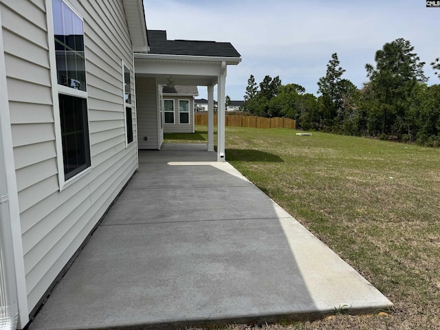 view of yard with fence, ceiling fan, and a patio