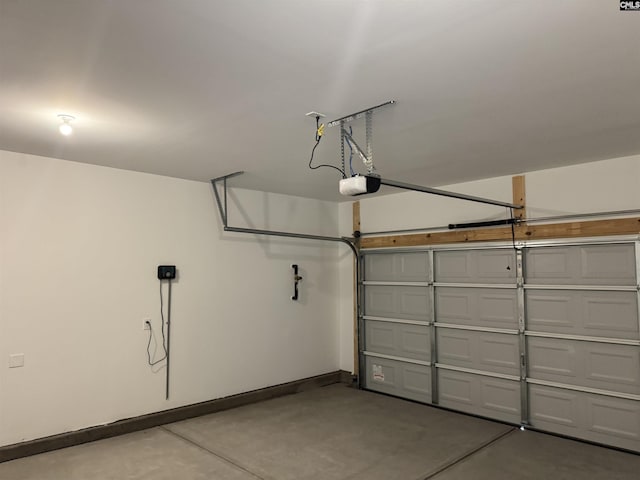 garage featuring a garage door opener and baseboards