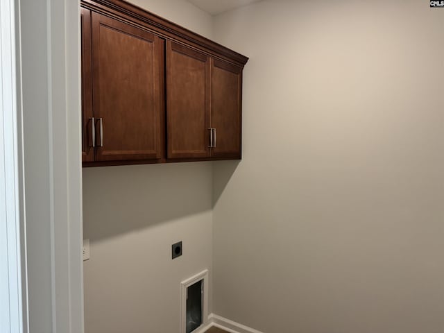laundry room with hookup for an electric dryer, cabinet space, and baseboards