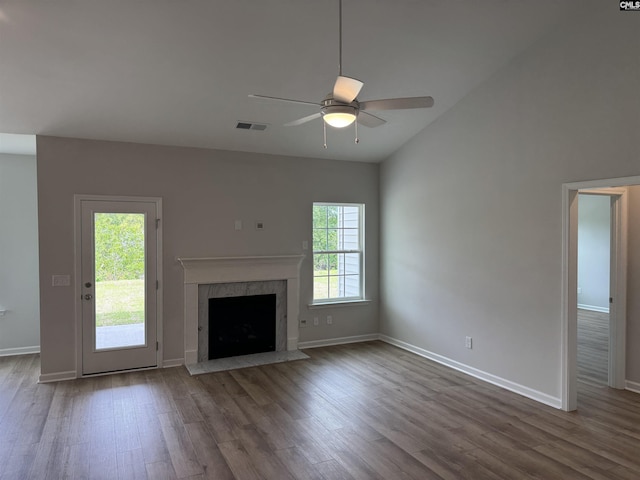 unfurnished living room featuring a fireplace, wood finished floors, a ceiling fan, and baseboards