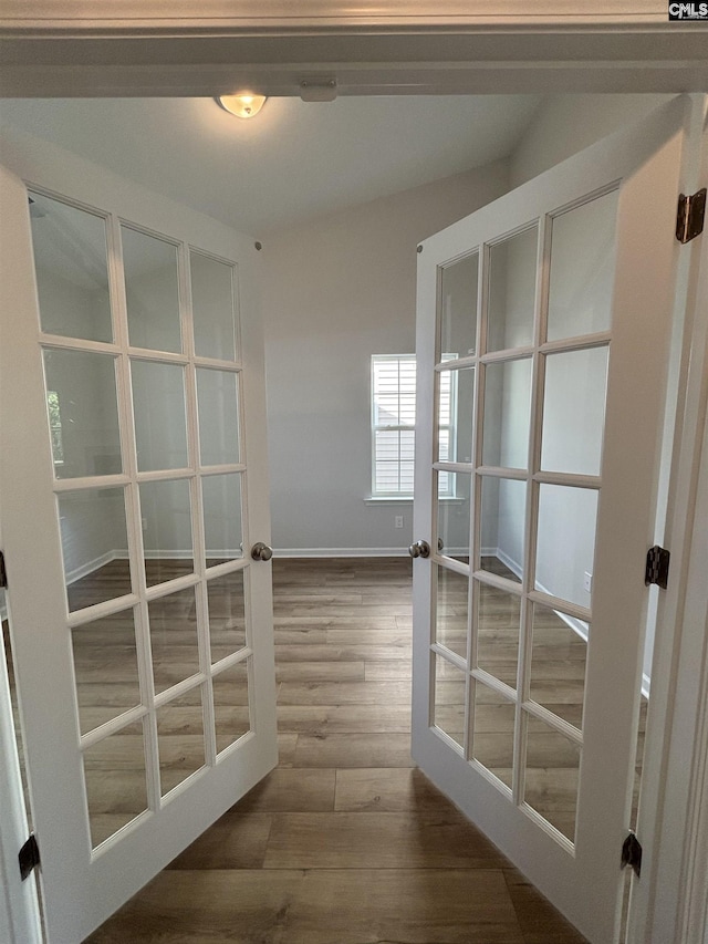 doorway featuring baseboards, french doors, and dark wood-type flooring