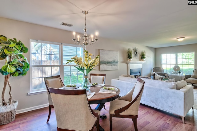 dining room with baseboards, wood finished floors, a notable chandelier, and visible vents