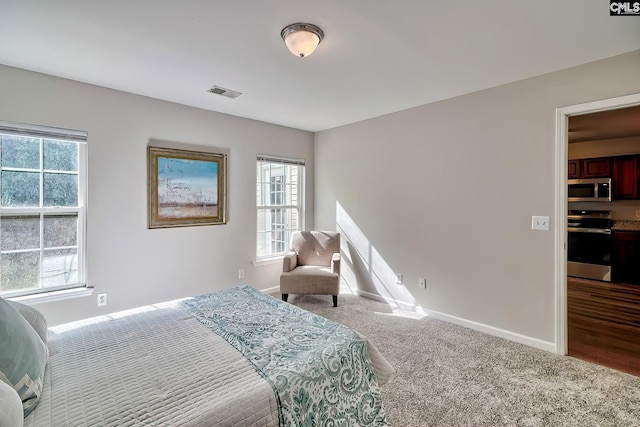 bedroom with visible vents, multiple windows, baseboards, and carpet floors