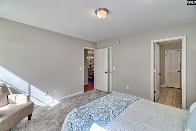 bedroom with a notable chandelier, baseboards, and carpet floors