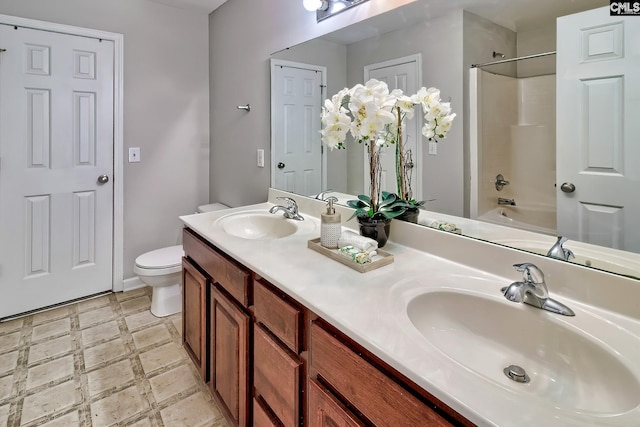 bathroom featuring toilet, tile patterned floors, double vanity, and a sink