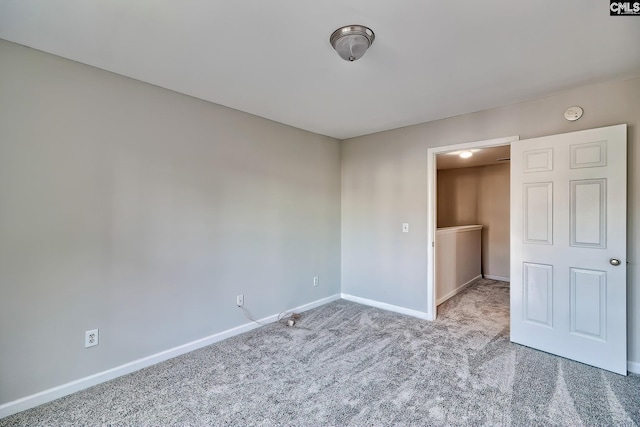 carpeted spare room featuring baseboards