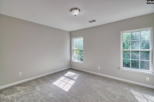 carpeted empty room featuring visible vents and baseboards