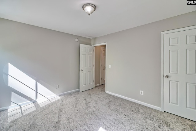 unfurnished room with baseboards and carpet