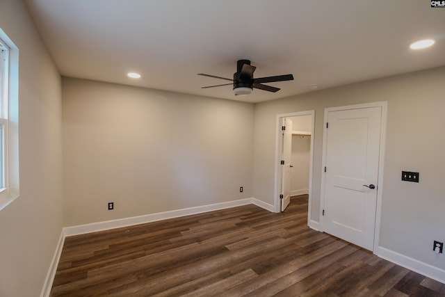 spare room featuring dark wood-type flooring, ceiling fan, and baseboards