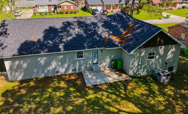 rear view of house with roof with shingles, a patio area, a residential view, and a lawn