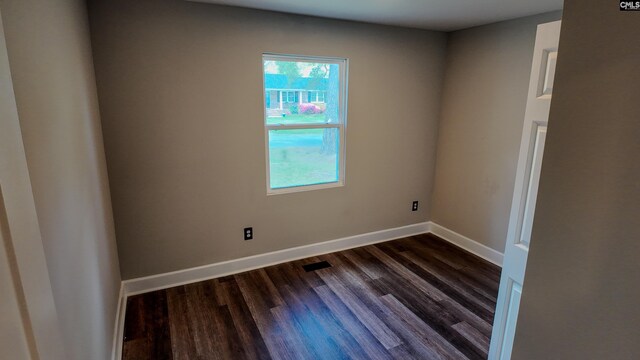 empty room with baseboards and dark wood-style floors
