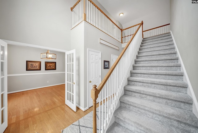 124 Pond Edge Ln, Chapin, SC 29036 - staircase featuring wood-type flooring, french doors, a high ceiling, and baseboards
