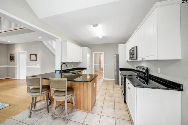 124 Pond Edge Ln, Chapin, SC 29036 - kitchen featuring a kitchen bar, a peninsula, white cabinetry, appliances with stainless steel finishes, and a sink