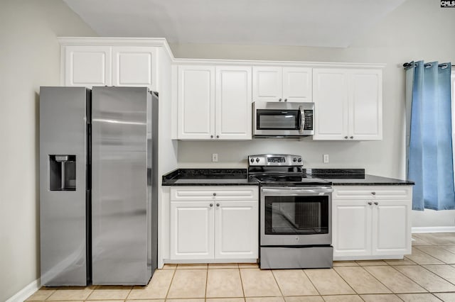 124 Pond Edge Ln, Chapin, SC 29036 - kitchen with dark stone counters, white cabinets, appliances with stainless steel finishes, light tile patterned flooring, and baseboards