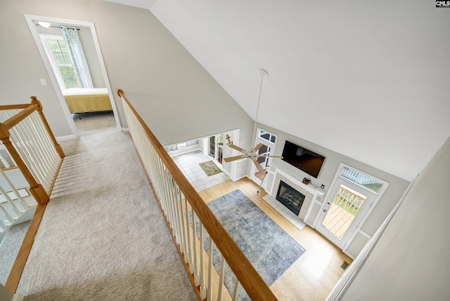 124 Pond Edge Ln, Chapin, SC 29036 - living area with baseboards, light wood finished floors, high vaulted ceiling, a glass covered fireplace, and light carpet