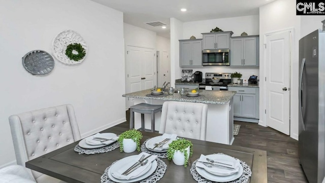 118A Willow Creek Blvd, Lugoff, SC 29078 - kitchen with an island with sink, gray cabinetry, visible vents, dark wood finished floors, and appliances with stainless steel finishes