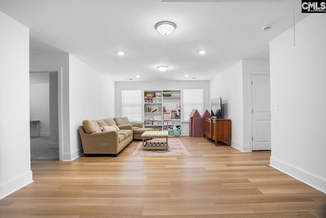 living area featuring light wood-style floors and baseboards