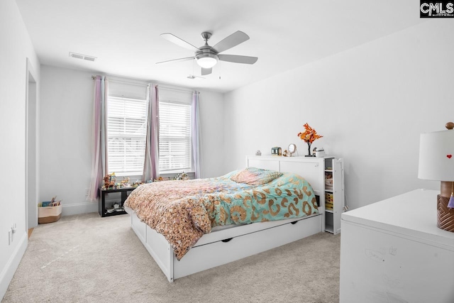bedroom featuring baseboards, visible vents, a ceiling fan, and light carpet