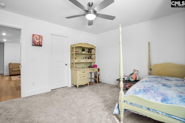 bedroom with light colored carpet, ceiling fan, and baseboards