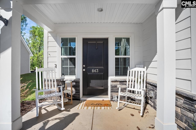 property entrance featuring a porch and stone siding