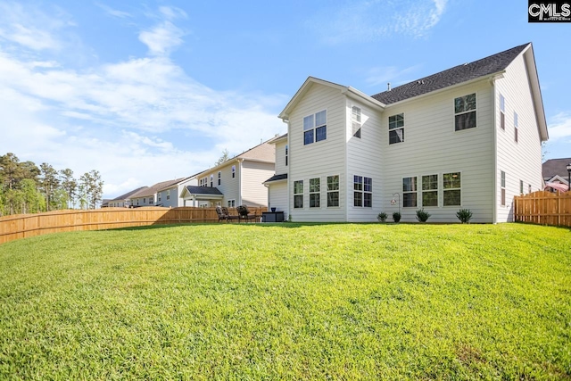 back of house featuring a yard and fence