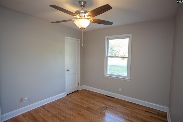 spare room featuring ceiling fan, baseboards, visible vents, and wood finished floors