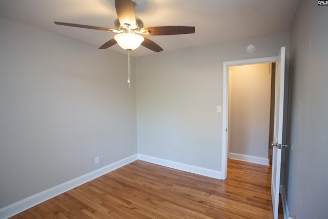 unfurnished room with light wood finished floors, baseboards, and a ceiling fan