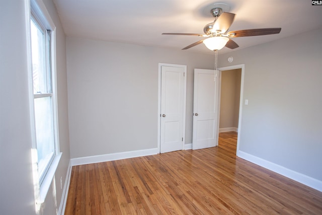 spare room featuring ceiling fan, wood finished floors, and baseboards