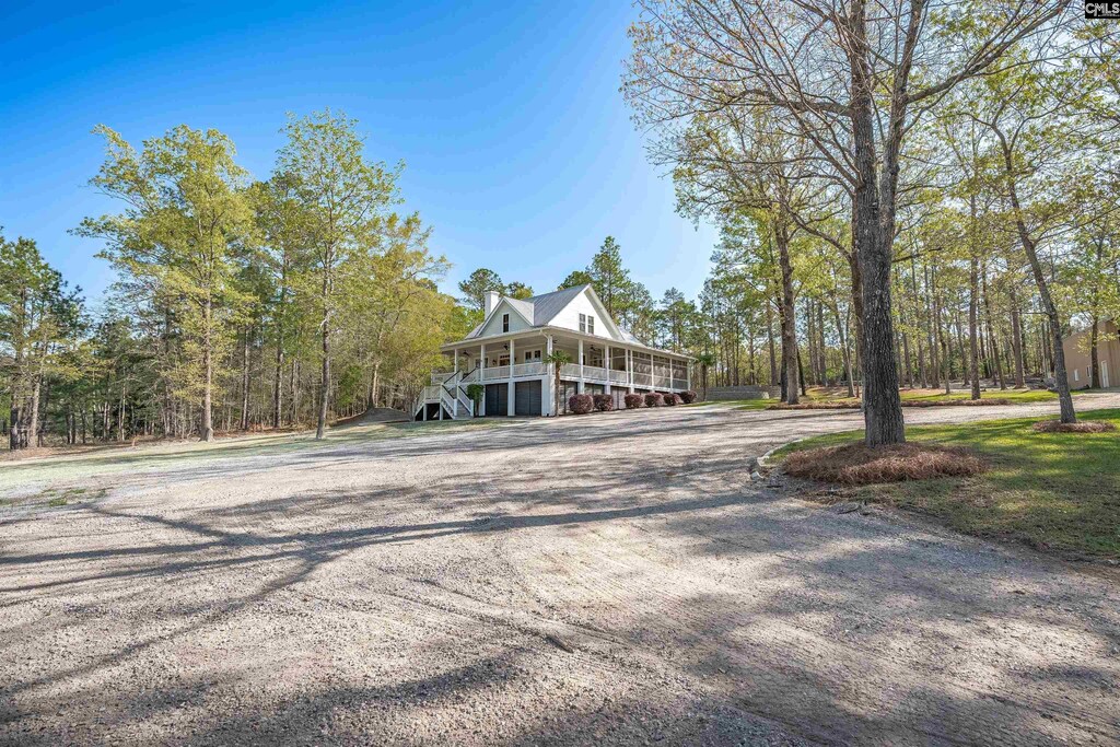 view of front of home with a carport, stairway, and driveway