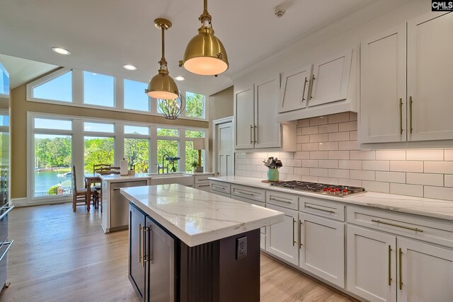209 Mariannas Ct, Lexington, SC 29072 - kitchen featuring hanging light fixtures, a center island, a sink, stainless steel appliances, and backsplash