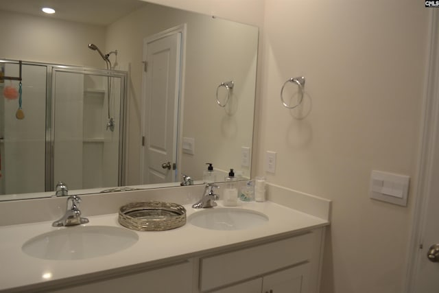 full bathroom with a shower stall, double vanity, and a sink