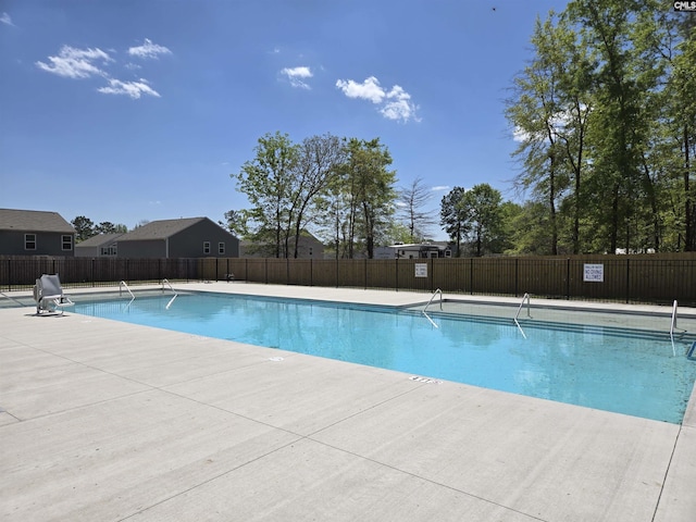 pool with fence and a patio