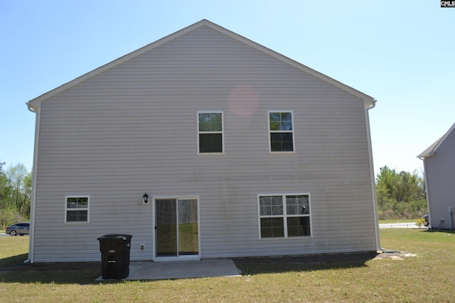 rear view of property featuring a patio and a lawn