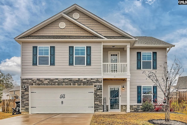 craftsman house with fence, concrete driveway, a garage, and stone siding
