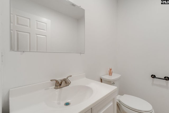 half bathroom with toilet and vanity
