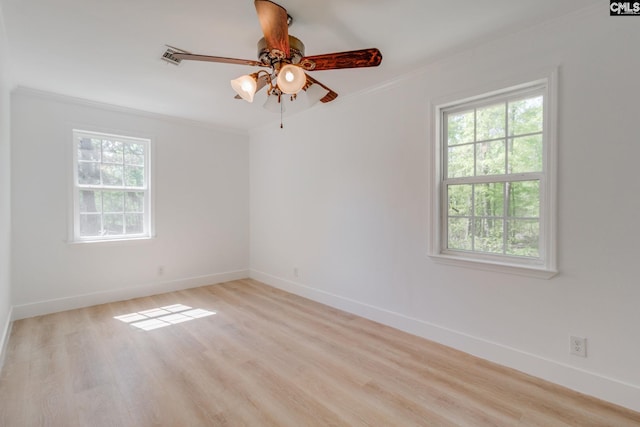 spare room with crown molding, a healthy amount of sunlight, and baseboards