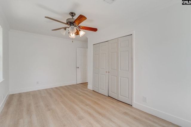 unfurnished bedroom featuring a closet, baseboards, ornamental molding, a ceiling fan, and wood finished floors