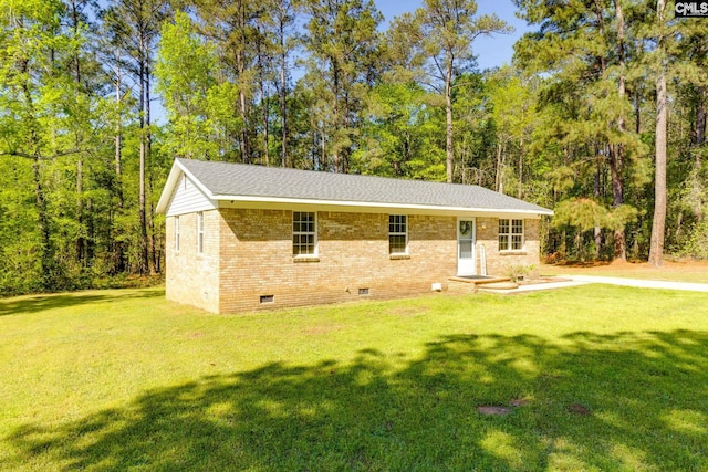 view of front facade featuring roof with shingles, brick siding, crawl space, and a front lawn