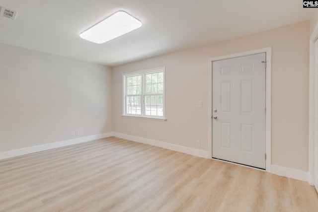 unfurnished room with visible vents, baseboards, and wood finished floors