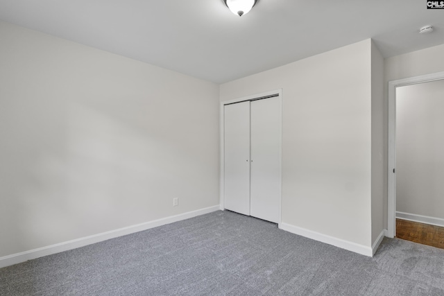 unfurnished bedroom featuring a closet, baseboards, and carpet