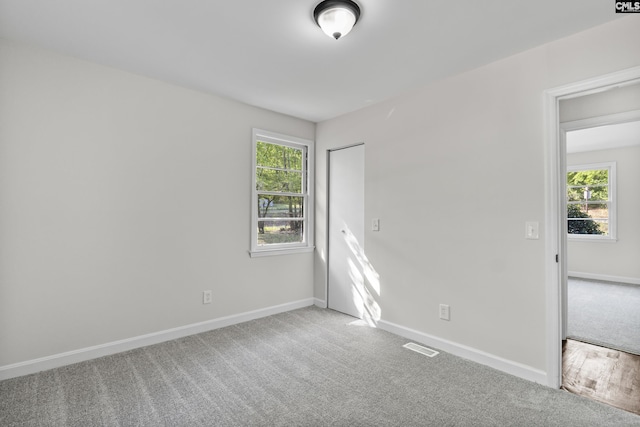 carpeted spare room with baseboards and a healthy amount of sunlight