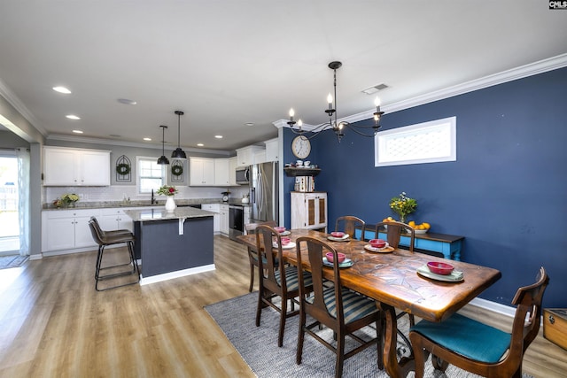 dining area with visible vents, an inviting chandelier, ornamental molding, light wood-type flooring, and recessed lighting