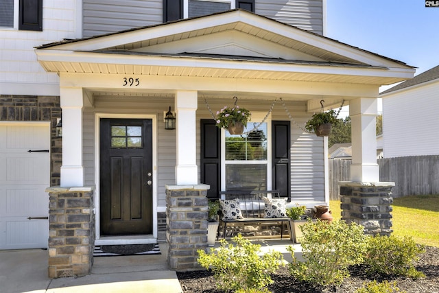 entrance to property with fence and covered porch