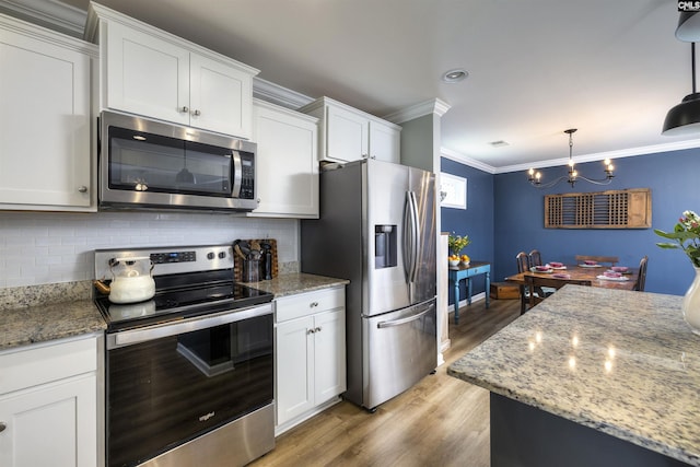 kitchen with tasteful backsplash, light wood-type flooring, appliances with stainless steel finishes, crown molding, and white cabinetry