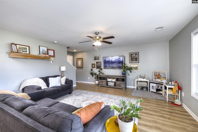 living room with visible vents, baseboards, a ceiling fan, and wood finished floors