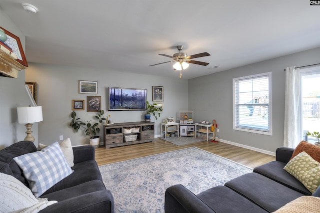 living room featuring wood finished floors, ceiling fan, and baseboards
