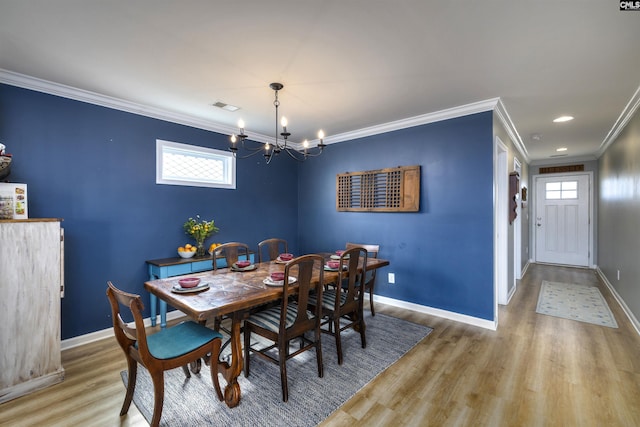 dining space featuring a notable chandelier, baseboards, light wood-type flooring, ornamental molding, and visible vents