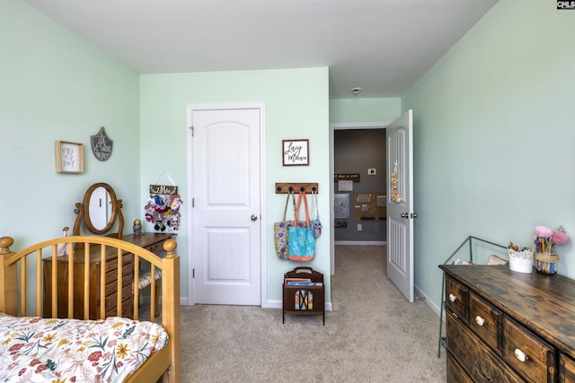 bedroom featuring light carpet and baseboards