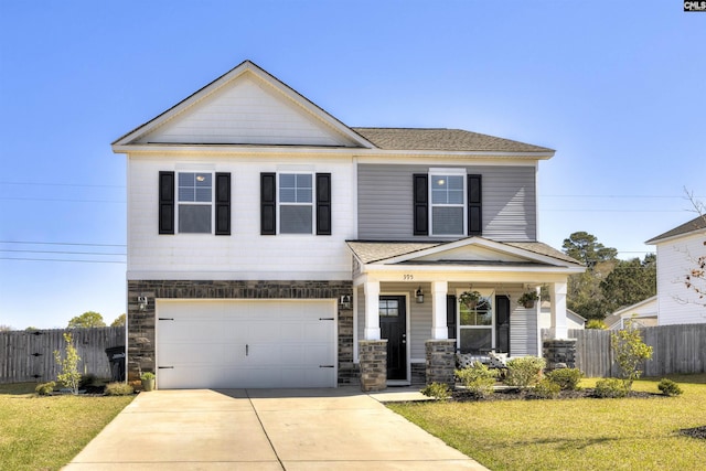 craftsman inspired home with an attached garage, concrete driveway, fence, and a front lawn